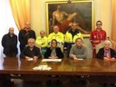 Seduti al tavolo, da destra Giorgio Bonini (Porta Aperta), assessore Giuliana Urbelli, Federico Valenzano (Centro Ascolto Caritas) e Ivana Rebecchi (Croce Blu). In piedi, volontari delle associazioni che firmano il protocollo 