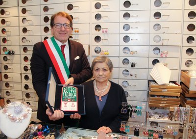 sindaco muzzarelli e dina serafini consegna targa botteghe storiche.jpg