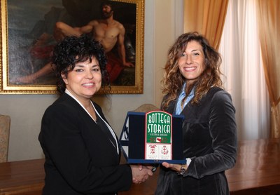 Monica Rossi titolare di Dallari abbigliamento riceve la targa dall'assessora Ludovica Carla Ferrari.jpg